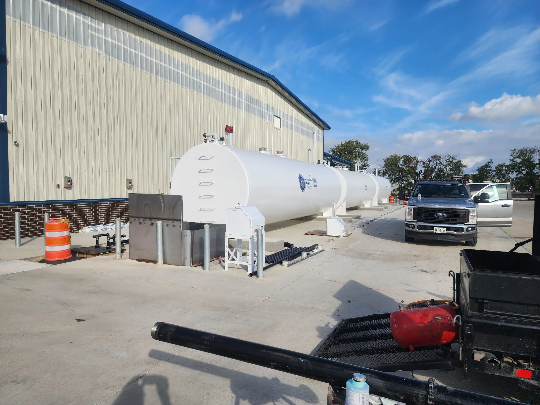 The completed tank installation beside the building, with a crew truck staged nearby